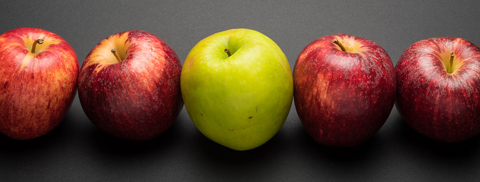 mixed color apples on dark background. Good for showing diversity and business teams