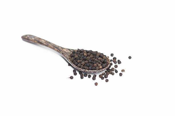 istock Black pepper in spoon wooden bowl isolated on white background 591433522