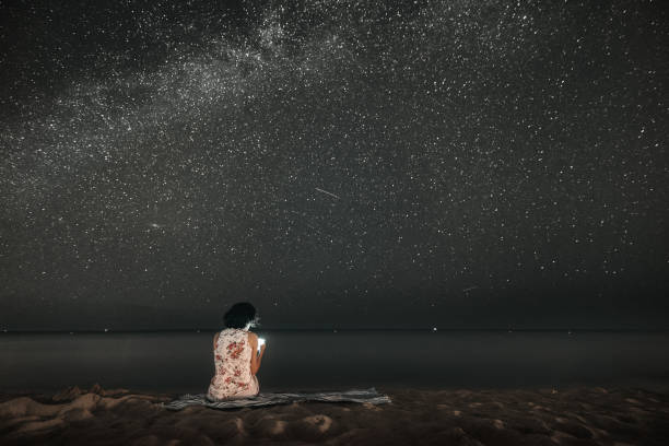 istock Woman Stargazing on the Beach 591433606