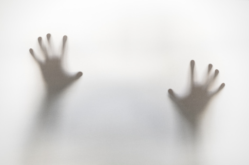 Silhouette of hands behind curtain with soft focus and blur