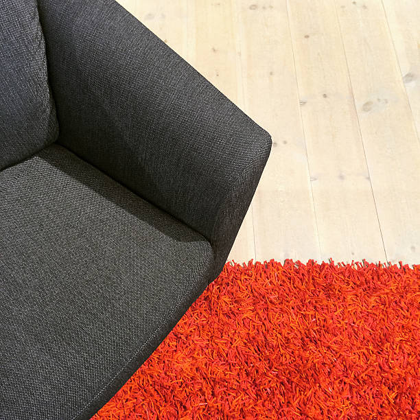 istock Gray textile armchair on red carpet 591435612
