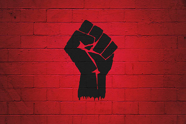 Fist power painted on a wall Black fist painted on a red brick wall. Ideal to serve as wallpaper or the base for a bigger composition. revolution stock pictures, royalty-free photos & images