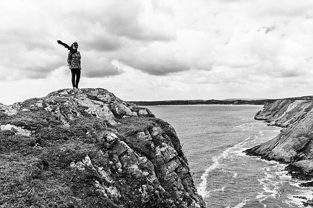 Mature hispanic woman walking on remote coastal headland
