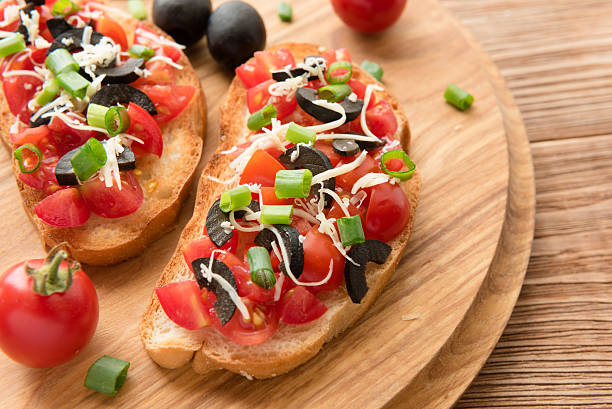 istock Preparing delicious Italian bruschetta with chopped vegetables 591441216