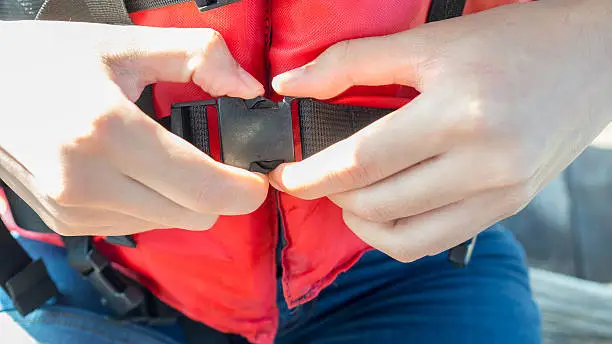 Pushing life jacket strap for safety.