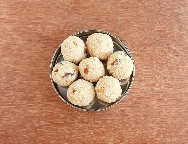 Indian sweet food rava laddu, which is a traditional and popular dish is made from semolina, raisins, almonds and sugar, in a steel plate. This sweet item is usually made for festivals like Diwali.