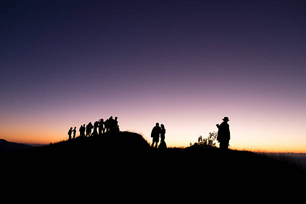 istock Silhouette of group people standing on the mountain 591445392