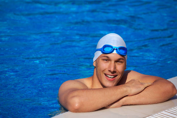 istock Young man relaxing in a pool    Male swimmer 591445554