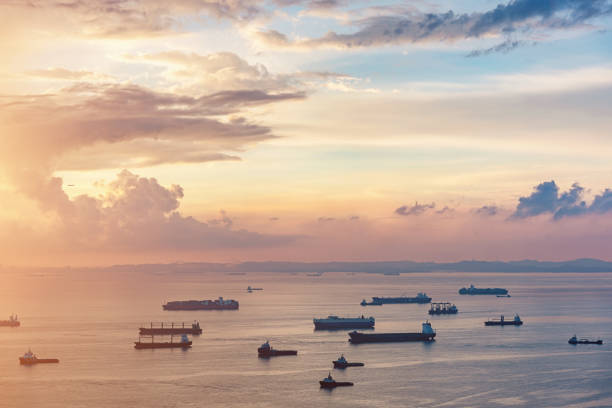 Aerial View Asian Container Ships Freight Transportation Sunrise Aerial view of freight transportation ships, container ships and industrial boats at beautiful sunrise twilight light to the horizon close to singapore city transportation hub harbor. Singapore Strait, Singapore, Asia. anchored photos stock pictures, royalty-free photos & images