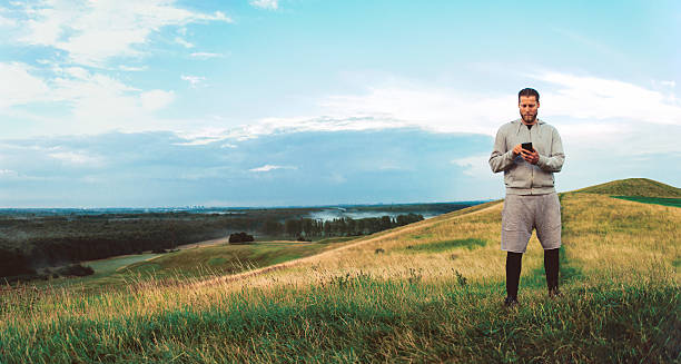 istock Runner stops running and looks at smart phone outside 591447790