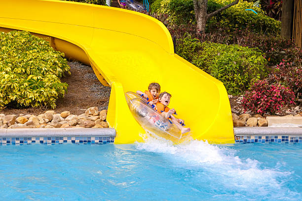 istock excited children in water park riding on slide with float 591798854