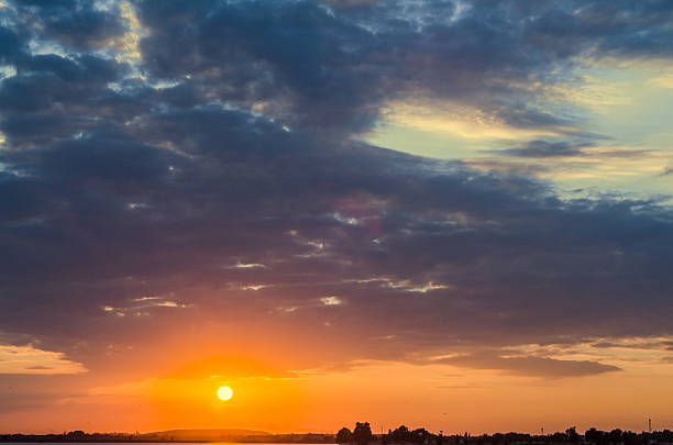 istock Orange sunset over a european lake, blue clouds sky 591799498