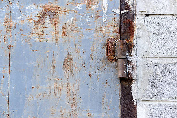 istock Scratched grunge damaged metal wall with gate hingers detailed texture 591801502