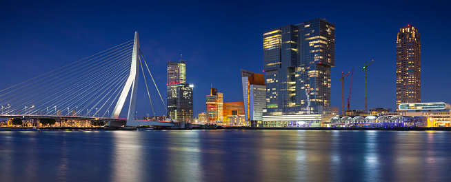 Panoramic image of Rotterdam, Netherlands during twilight blue hour. This is composite of two horizontal images stitched together in photoshop.