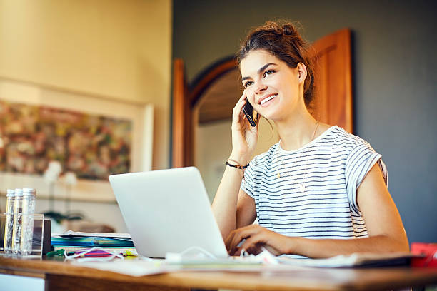 istock Thoughtful happy woman talking on smart phone at table 591810300