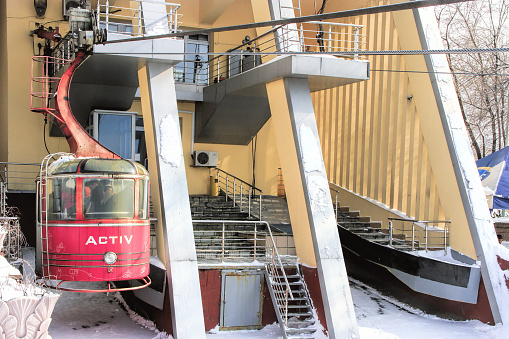 Almaty, Kazakhstan - March 10, 2014: funicular with tourists and view of the foggy city of Almaty, the south capital of Kazakhstan on winter.