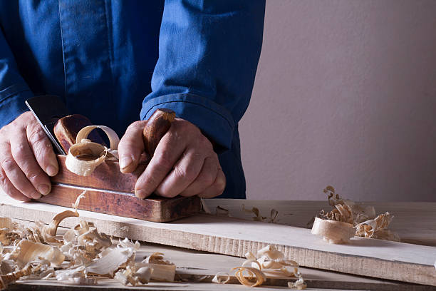 istock Carpenter working with plane on wooden background at Building Site 591811562