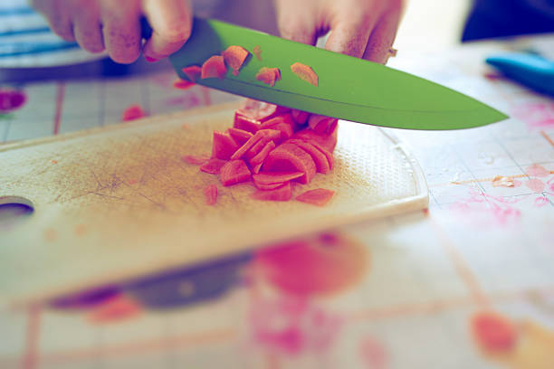 unrecognizable woman hands cutting carrots and preparing healthy food with vegetables.