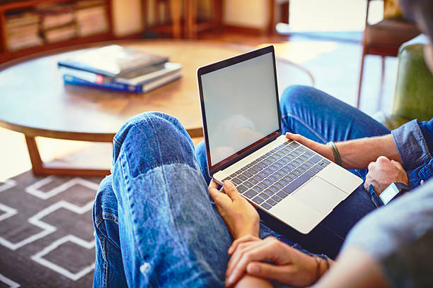 istock Young couple using laptop on sofa in living room 591816458