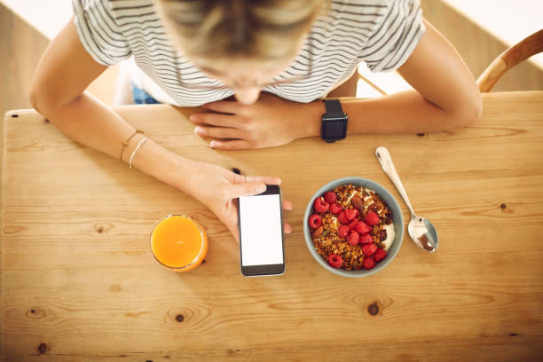 istock Overhead of blogger with smart phone and breakfast at table 591817966