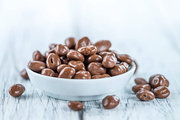 istock Old wooden table with Chocolate Raisins 591818952