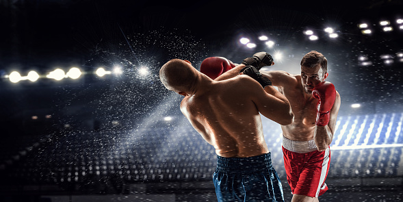 Two professional boxers are fighting on arena panorama view