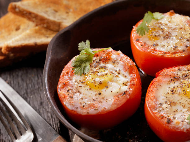 huevos horneados en tomates - sunnyside fotografías e imágenes de stock