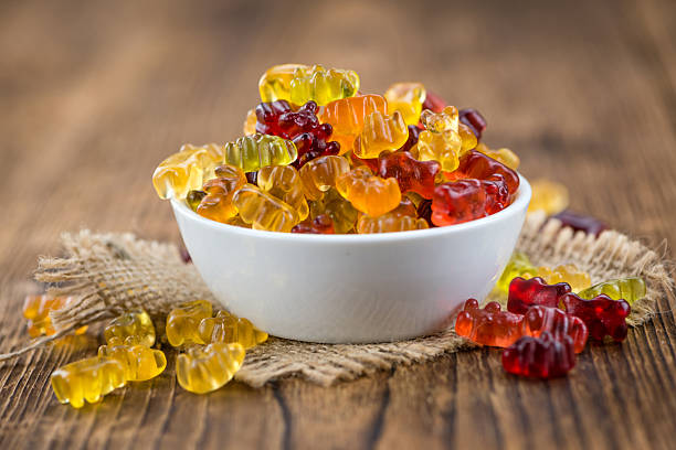 Fruity Gummy Bears (close-up shot) Fruity Gummy Bears (close-up shot) on an old wooden table gummi bears stock pictures, royalty-free photos & images