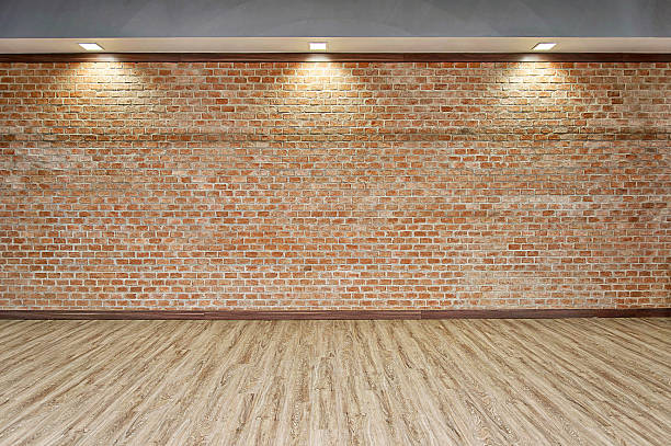 BRICK WALL WITH WOOD FLOOR BACKGROUND ROOM INTERIOR WITH BRICK WALL AND THREE SPOTLIGHTS AND WOOD FLOOR BACKGROUND film studio stock pictures, royalty-free photos & images