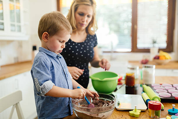 istock Smart cute child helping mother in kitchen 591828486