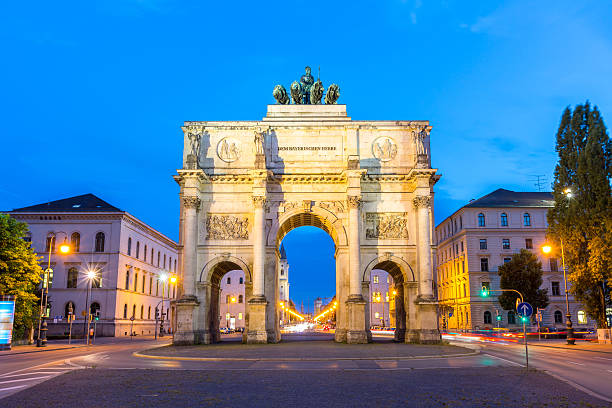 Victory Arch in Munich The Siegestor Victory Arch in Munich at dusk with traffic going around the arch. siegestor stock pictures, royalty-free photos & images