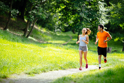 Athletic couple jogging in nature in good spirit