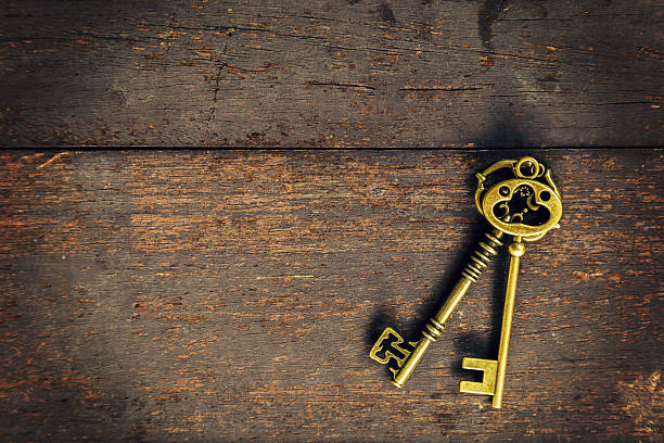 istock Old vintage key on wood texture background with space 591833048