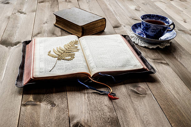 istock Open and closed Bibles with cup of tea 591833900