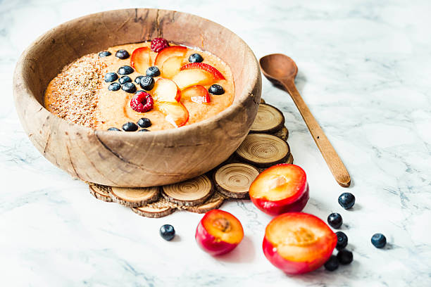 smoothie bowl with peaches, plums and blueberries stock photo