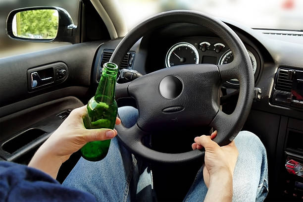 認識できない男の飲酒運転。危険なドライビングコンセ - drunk teenager men drinking ストックフォトと画像