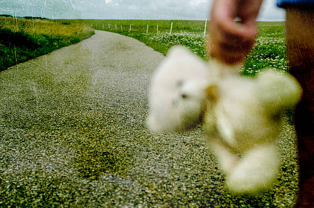 istock Refugee child goes on the road with her teddy bear 591838630