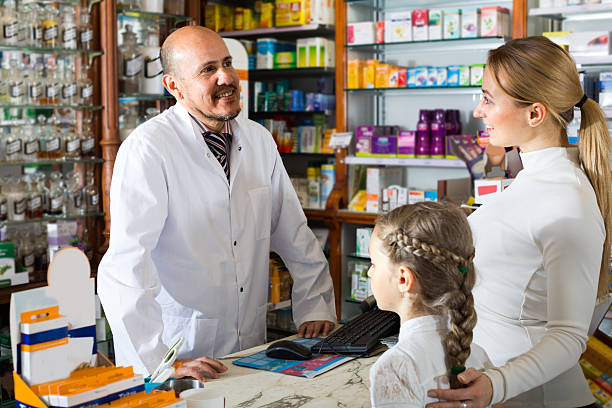 istock pharmacist standing with a cash desk 591841250
