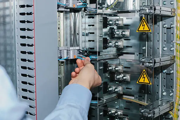 Photo of Electrician near the low-voltage cabinet. Uninterrupted power supply. Electricity.