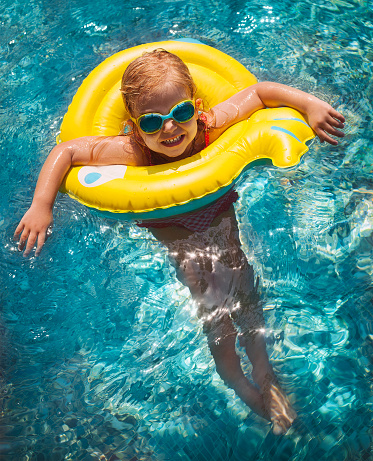 Happy child playing in swimming pool. Summer vacations concept