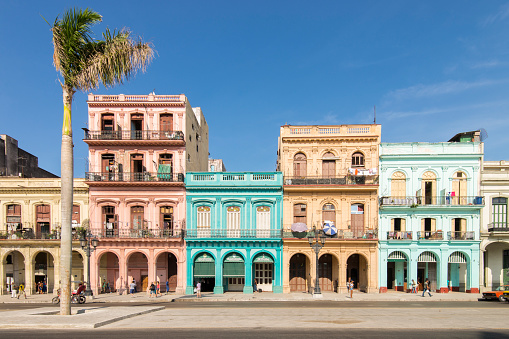 Havana, Cuba - April 8, 2016: View of a street at Old Havana, Cuba. The city is an Unesco World Heritage Site. Cubans people and turists walking sorrounded by colored old buildings.