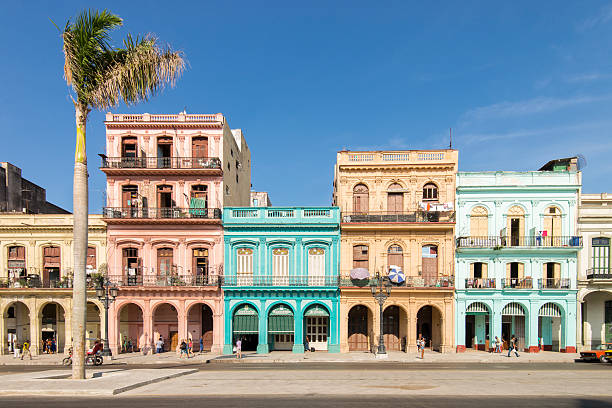 Street at Old Havana, Cuba. Havana, Cuba - April 8, 2016: View of a street at Old Havana, Cuba. The city is an Unesco World Heritage Site. Cubans people and turists walking sorrounded by colored old buildings. havana photos stock pictures, royalty-free photos & images