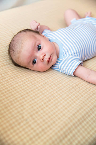 istock Baby Boy in Blue & White Laying in Crib 591846312