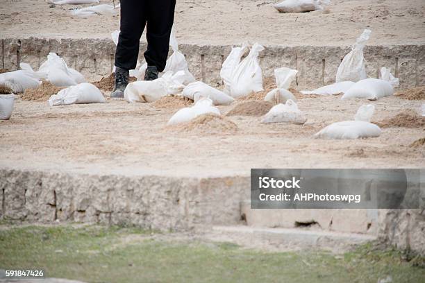 Sandbags Flood Prevfention And Man Stock Photo - Download Image Now - Assistance, Sandbag, Accidents and Disasters