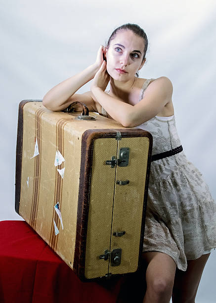 istock Attractive Female Leaning On Her Antique Suitcase 591850842