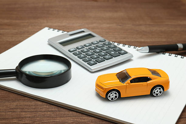 toy car, magnifying glass, calculator, pen and notebook. - bilförsäkring bildbanksfoton och bilder