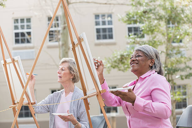 istock Two senior women having fun painting in art class 591852404