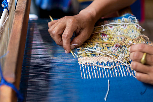 istock Thai girl using quill for weaving 591984892
