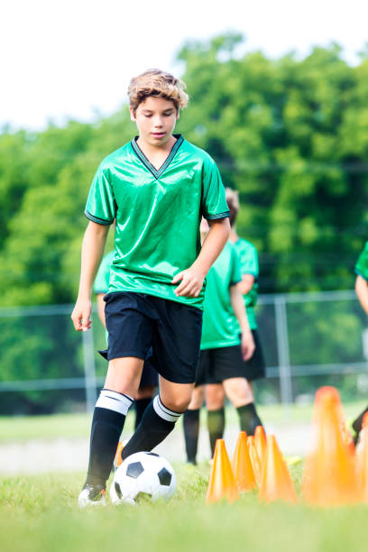 istock Teenage soccer player runs through drills with team 591985484