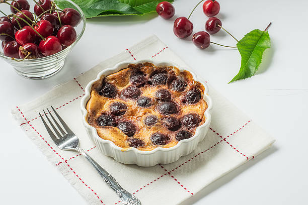 Clafoutis, cherry dessert on white with fresh cherries A traditional french desert, preferably with bitter cherries, here made with locally grown cherries. clafoutis stock pictures, royalty-free photos & images